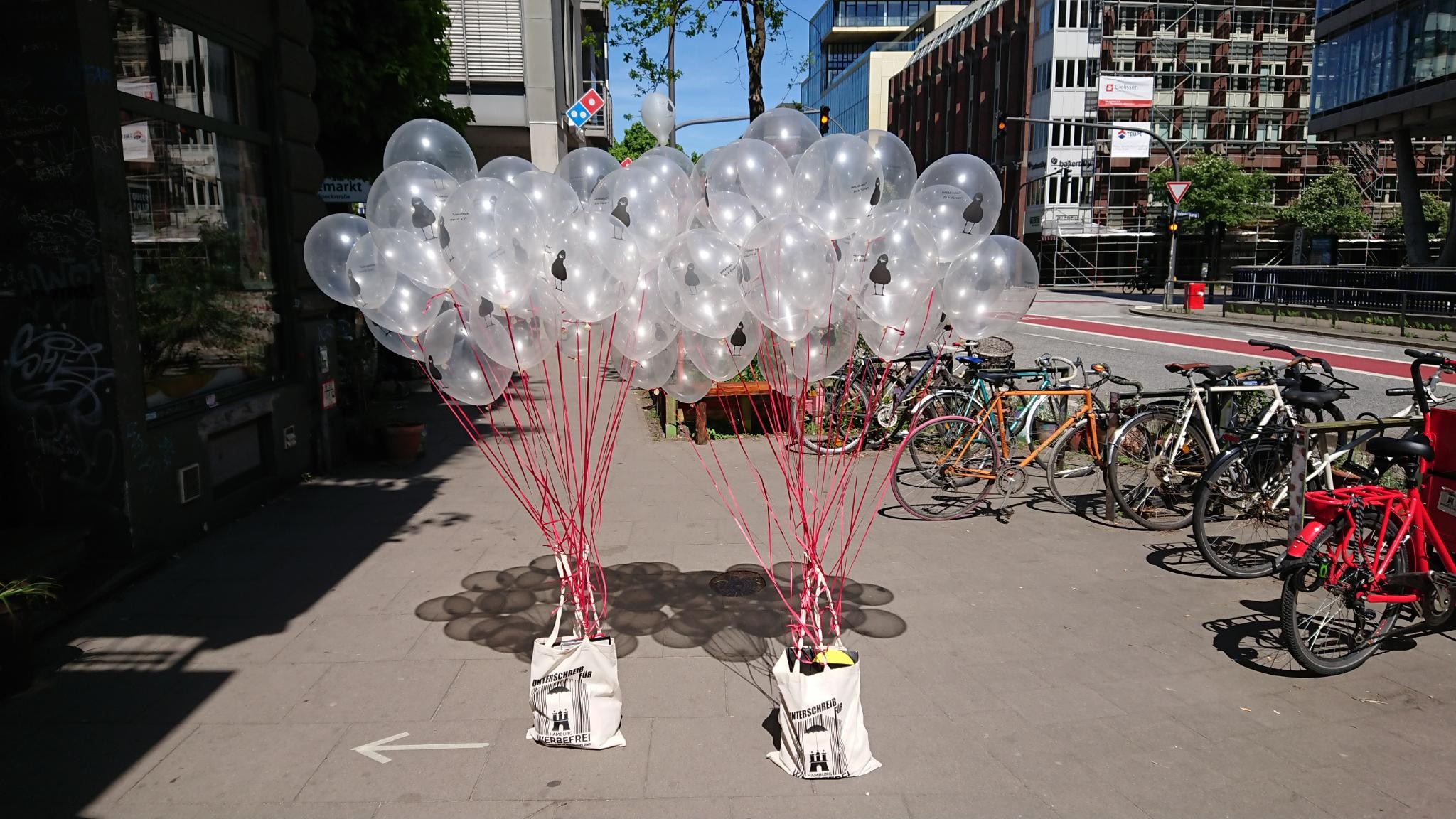 Zwei Hamburg-Werbefrei-Taschen, von denen viele Heliumballons nach oben hängen, stehen auf dem Gehsteig der Caffamacherreihe.