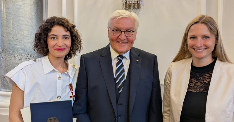 Das Bild zeigt Vertreterinnen von HateAid mit dem Bundespräsidenten, die gut gelaunt in die Kamera lächeln.